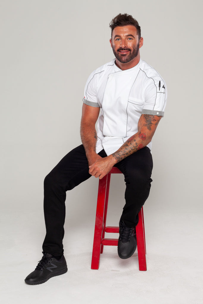 chef sitting on a stool and posing for chef jackets by ace chef 